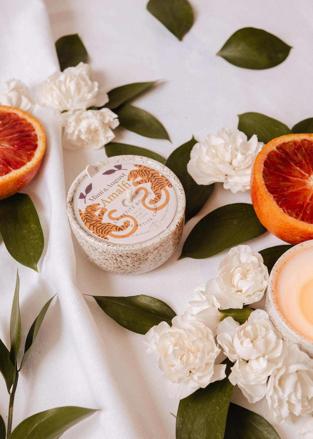 Mimi & August Amalfi reusable candle in a 3 oz glass jar with a lit wick and decorative label, ideal for home decor and ambiance.