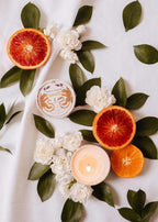 Mimi & August Amalfi reusable 3 oz candle in a sleek glass container with a lit wick and a fresh, citrus-inspired scent.