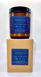 A tall candle from The InnerCandescent Co's AQUA SOLACE line, featuring a fresh aquatic scent with coconut and apricot wax.