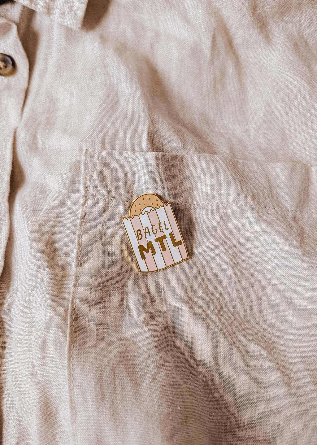 Mimi & August Bagel MTL enamel pin featuring a detailed, colorful bagel design on a metal pin backing.