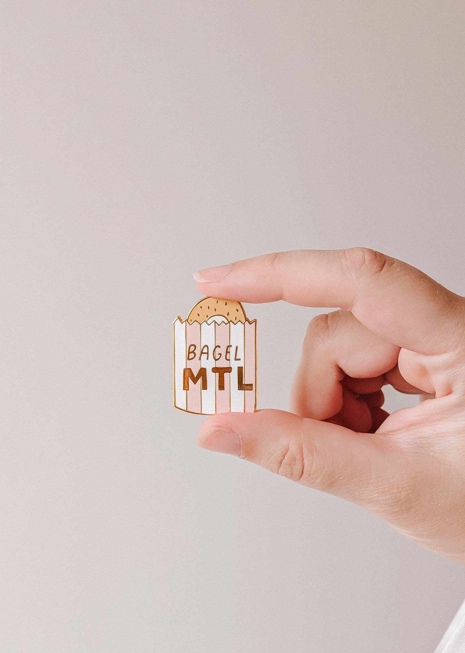 Mimi & August Bagel MTL enamel pin featuring a detailed bagel design on a metal pin backing.