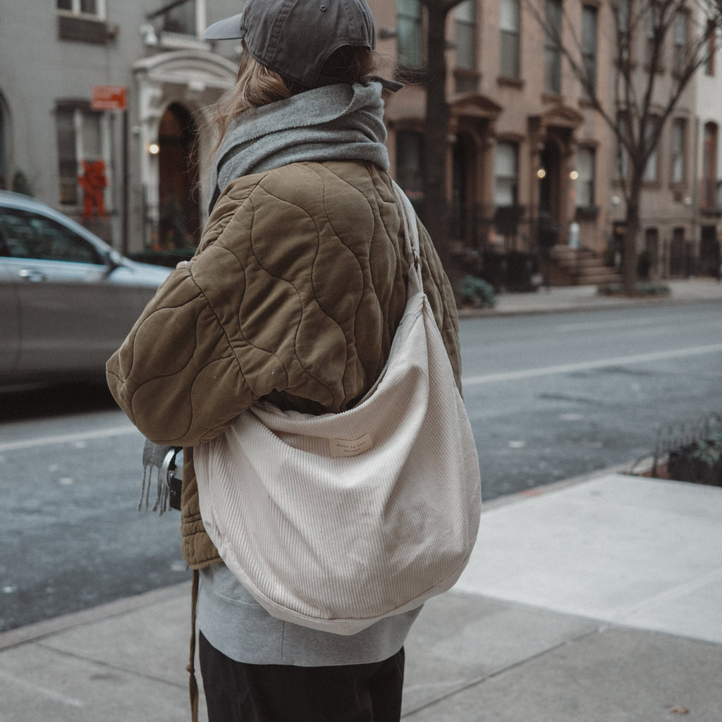 Reusable corduroy croissant bag with adjustable strap and zipper closure by Dans Le Sac, featuring a stylish, compact design.