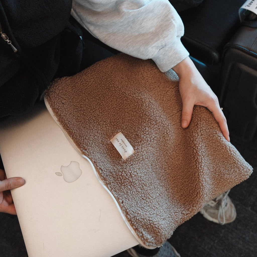 Dans Le Sac fabric laptop sleeve with a sleek, minimalist design, shown open with a laptop inside.