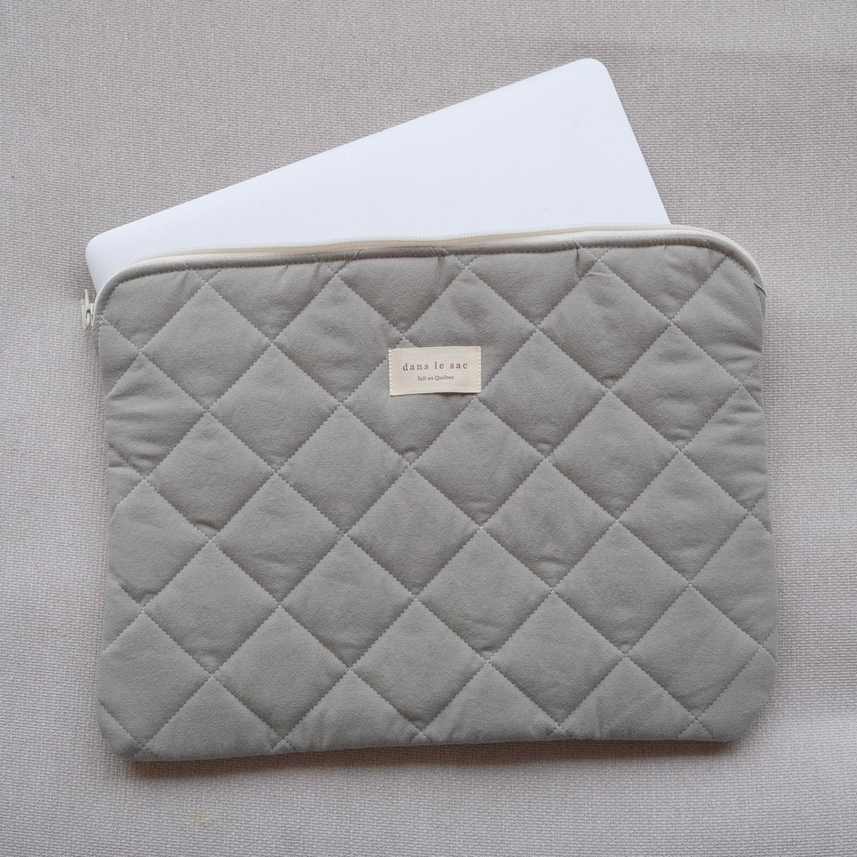 Dans Le Sac fabric laptop sleeve with a sleek design, featuring a soft interior and secure zipper closure for protection.