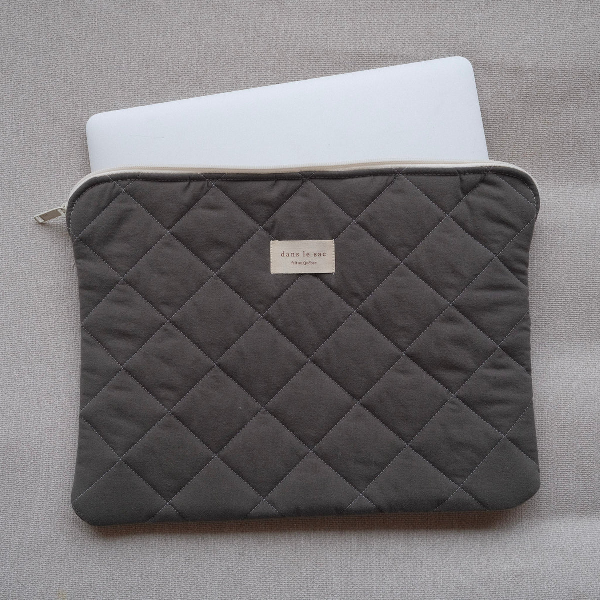 Tissu pochette pour ordinateur de la marque Dans Le Sac, avec fermeture et intérieur rembourré pour protection.