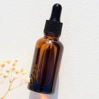 Facial serum and Gua Sha massage tool with hemp and chamomile, natural skincare product from La Sultana Savonnerie.