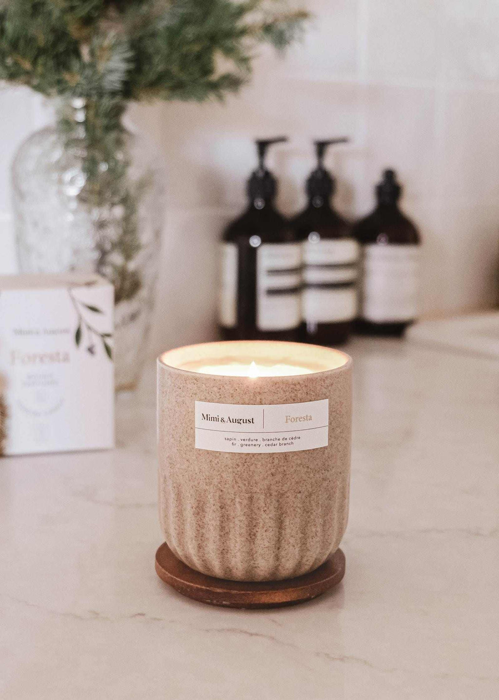 Foresta reusable candle by Mimi & August showing a natural wood-inspired design in a clear glass container.