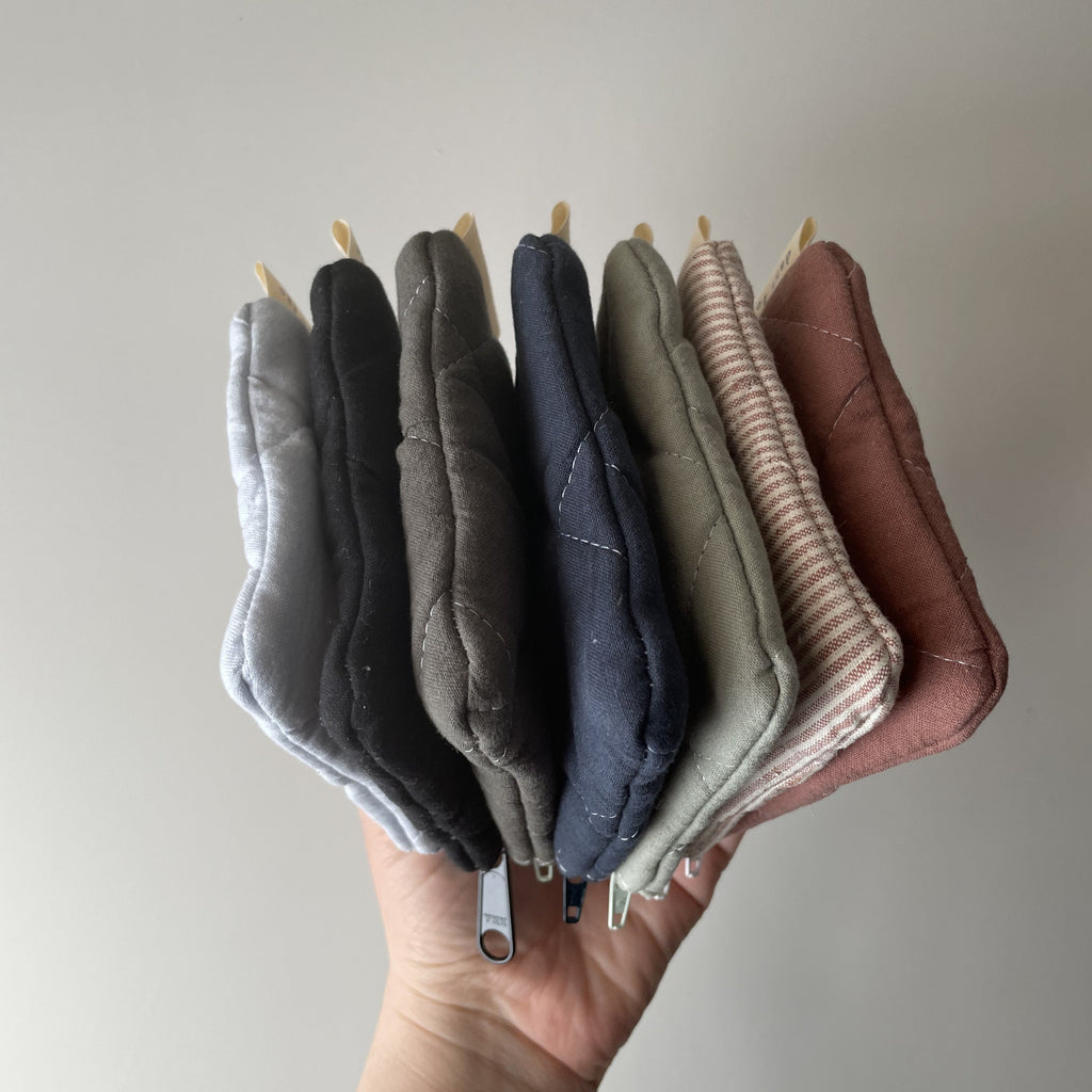 Reusable Dans Le Sac quilted cotton coin purse with a soft, padded design and compact shape for easy carrying.