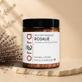 Natural bath salts with jojoba oil and rose petals from La Sultana Savonnerie, shown in a clear container with pink and white salts.