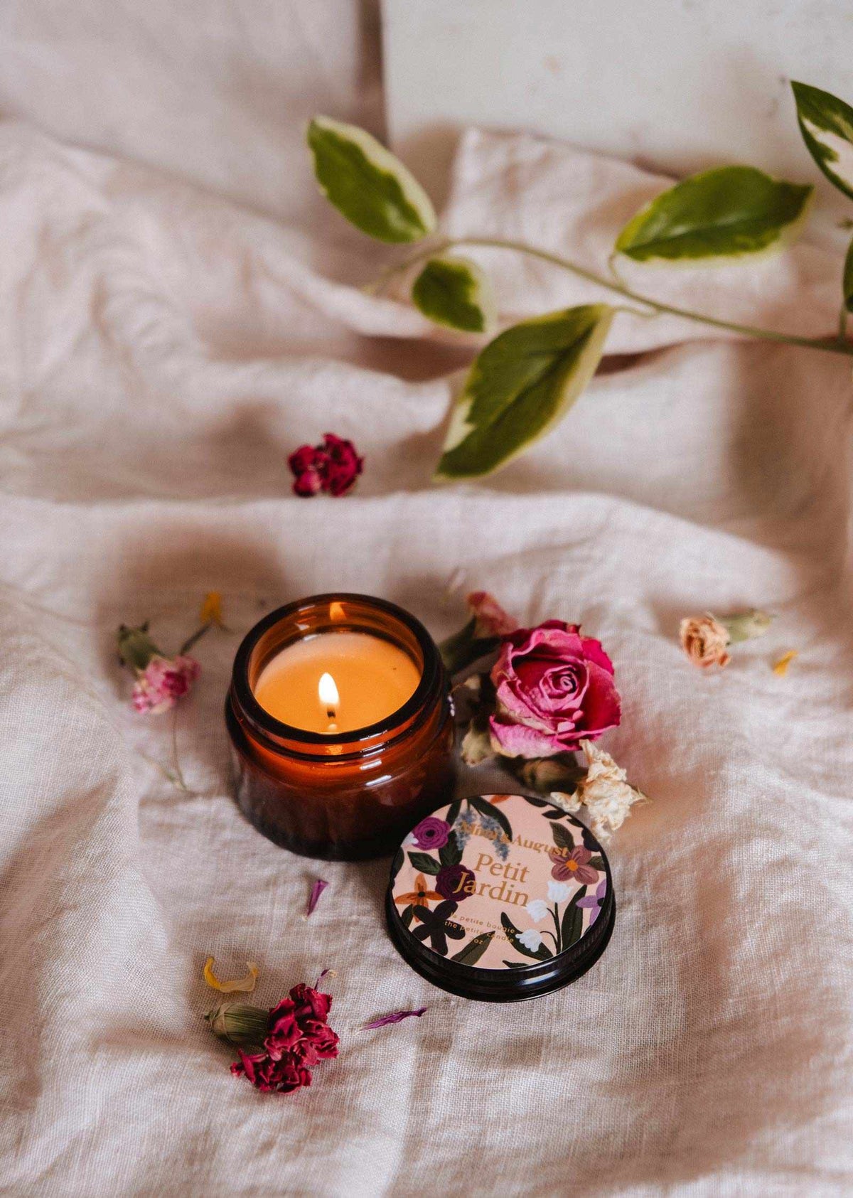 Petit Jardin 2 oz soy candle by Mimi & August, small glass jar with botanical label and white wax interior.