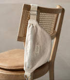 Reversible Dans Le Sac reusable zip closure waist bag with black and beige fabric, compact and lightweight accessory.