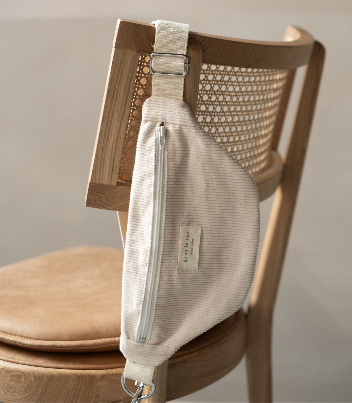 Reversible Dans Le Sac reusable zip closure waist bag with black and beige fabric, compact and lightweight accessory.