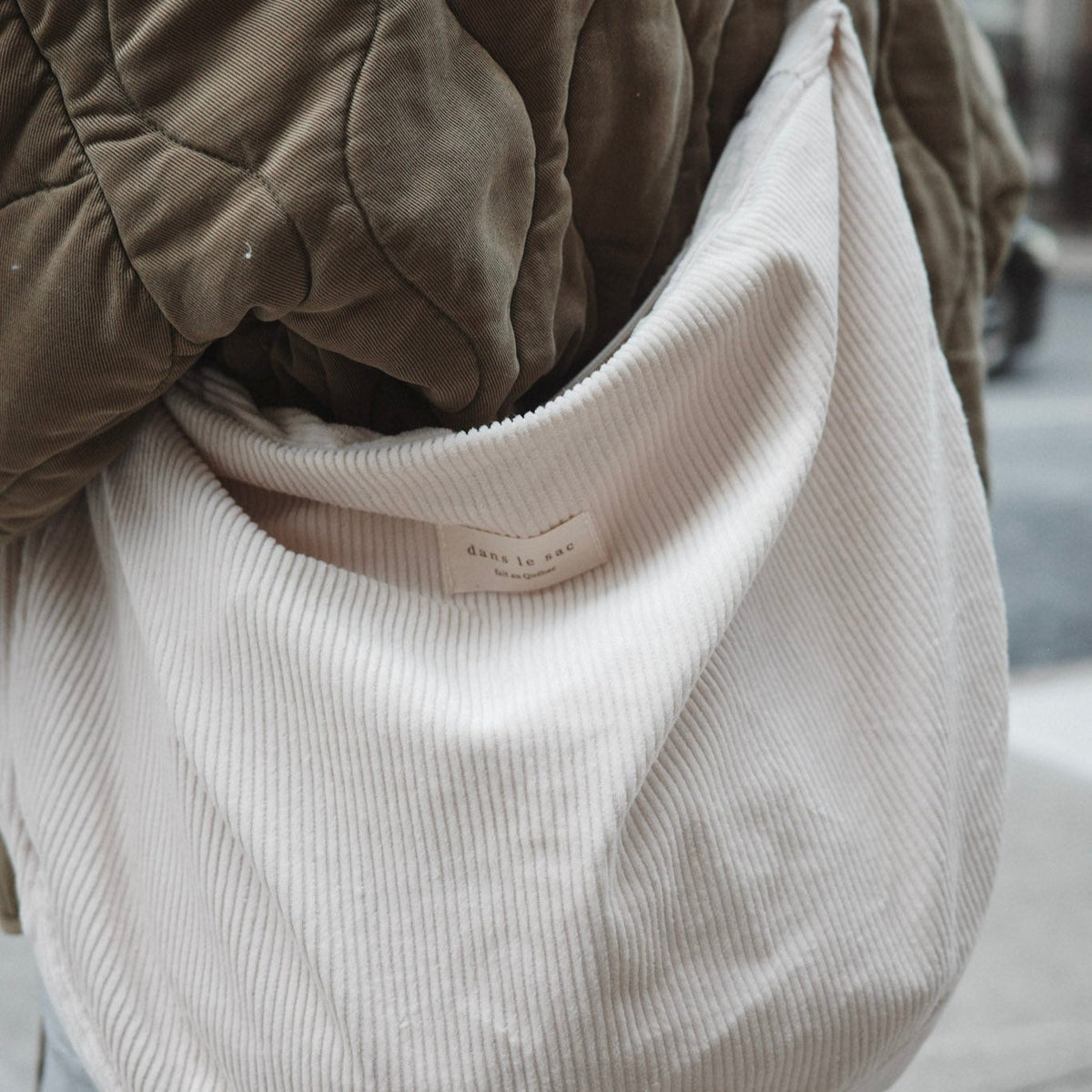 Dans Le Sac reusable corduroy croissant bag with adjustable shoulder strap and zipper closure, stylish and eco-friendly accessory.