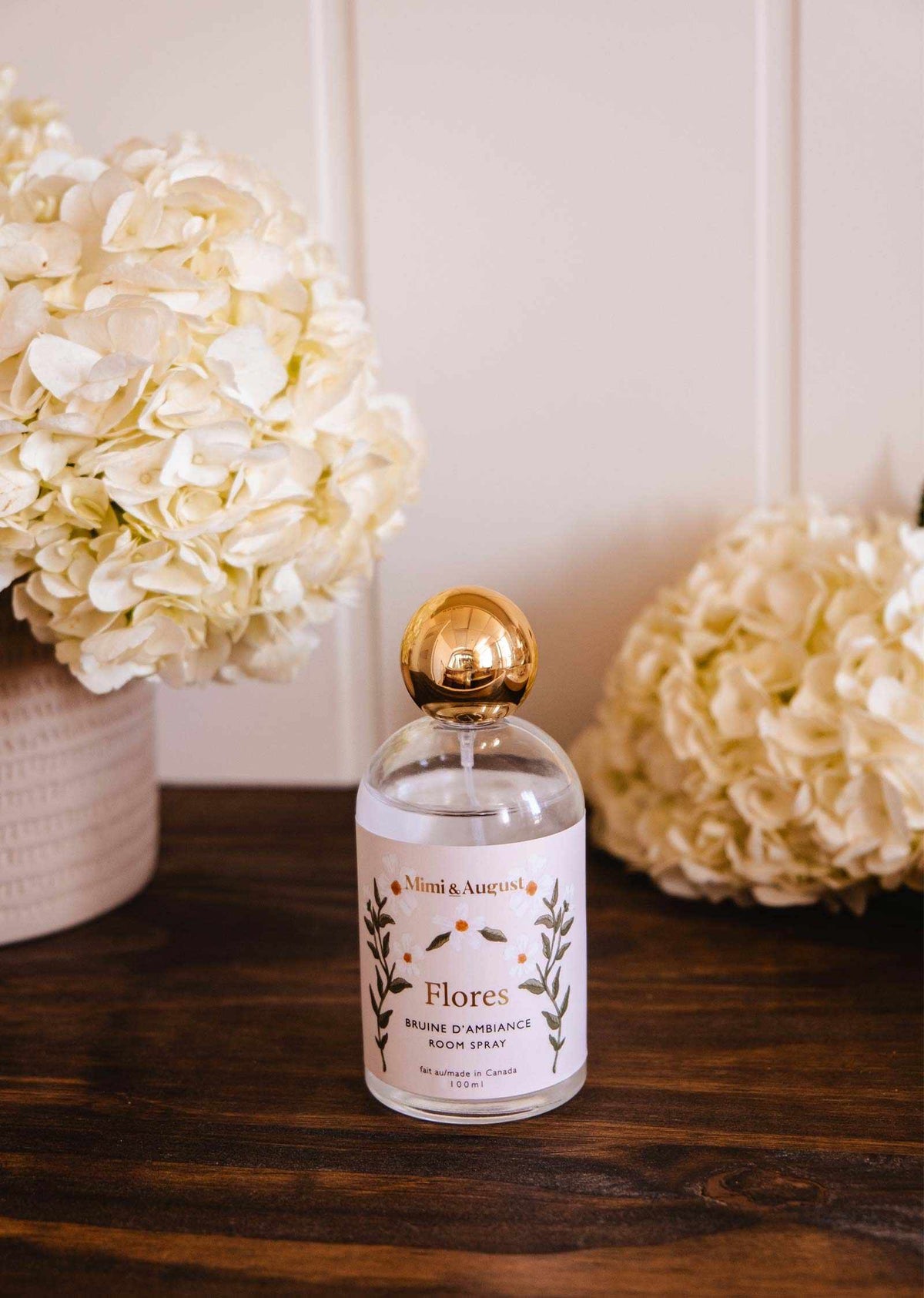 Mimi & August Flores room spray in a brown ambiance bottle, showcasing elegant packaging and floral design.