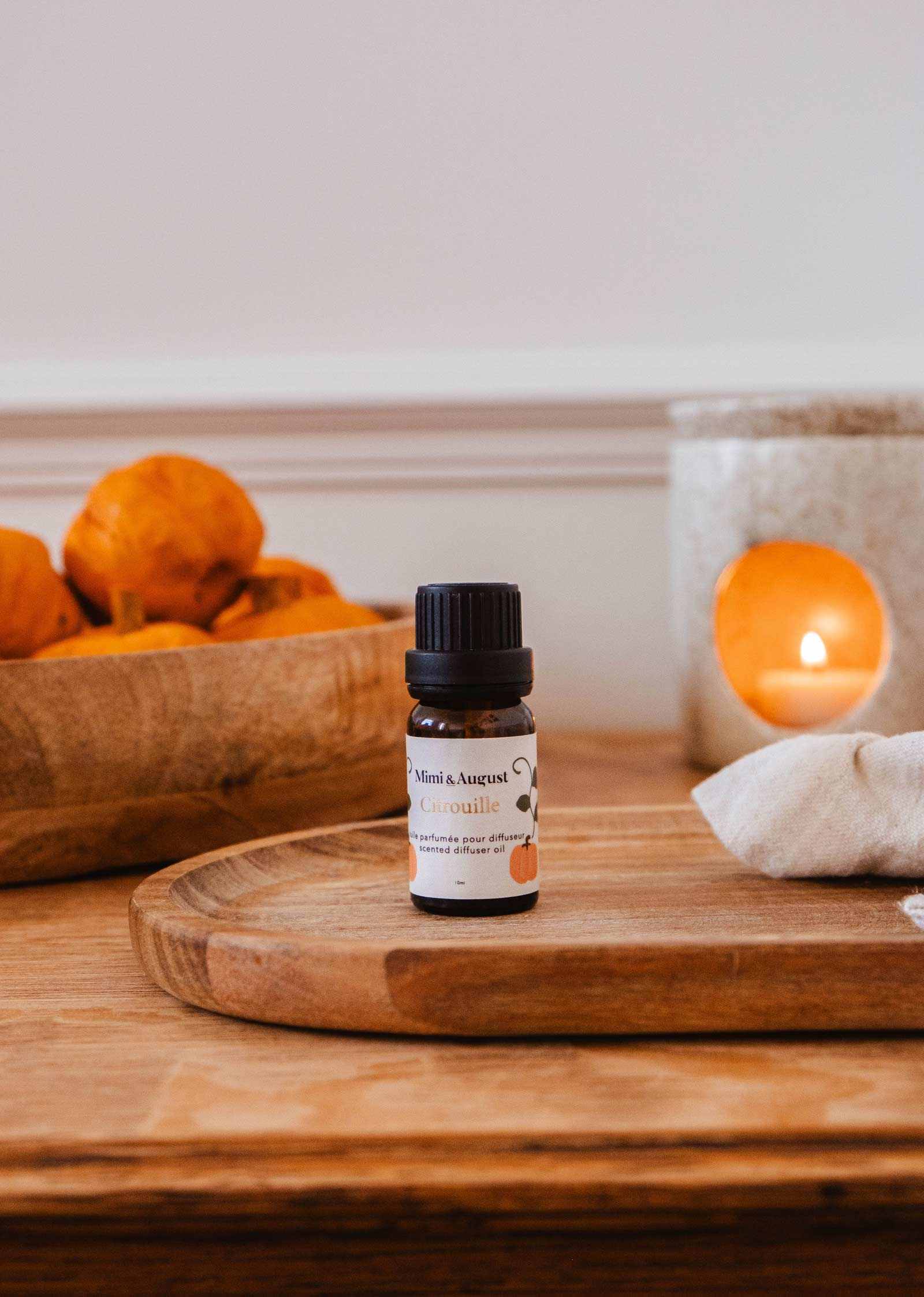 Mimi & August scented oil with pumpkin (Citrouille) aroma, showcasing a glass bottle with a metal cap and orange-hued oil.