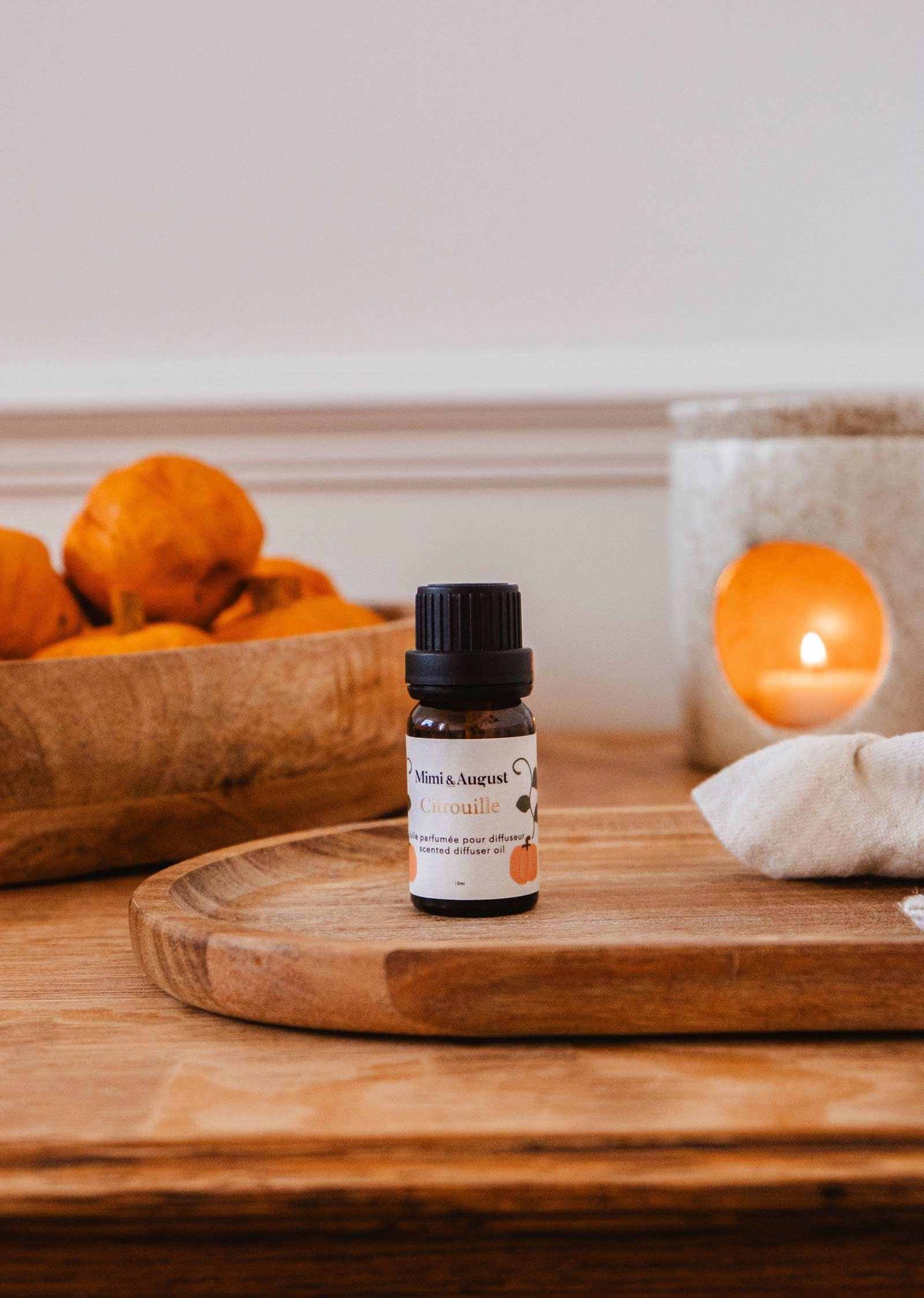 Mimi & August scented oil with pumpkin (Citrouille) aroma, showcasing a glass bottle with a metal cap and orange-hued oil.