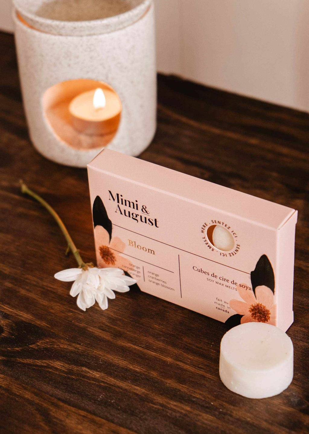 Soy wax melts in Bloom scent by Mimi & August, featuring colorful floral-shaped wax tarts in a clear container.