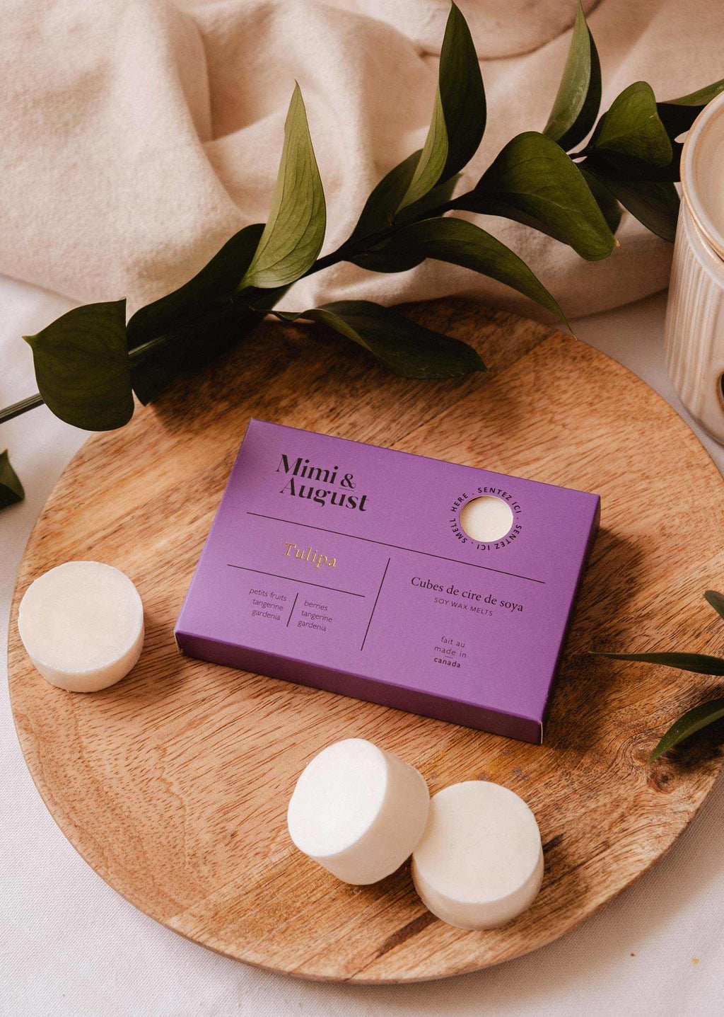 Soy wax melts in tulip scent by Mimi & August, showcasing a set of colorful wax tarts arranged in a decorative display.