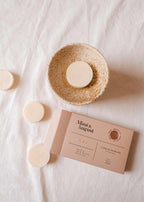 Soy wax melts in Cielo scent by Mimi & August, displayed in a clear container with a floral background.
