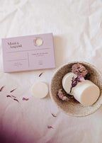 Soy wax melts in lilac color, Mimi & August wax tarts with floral scent, displayed in a clear container on a neutral background.
