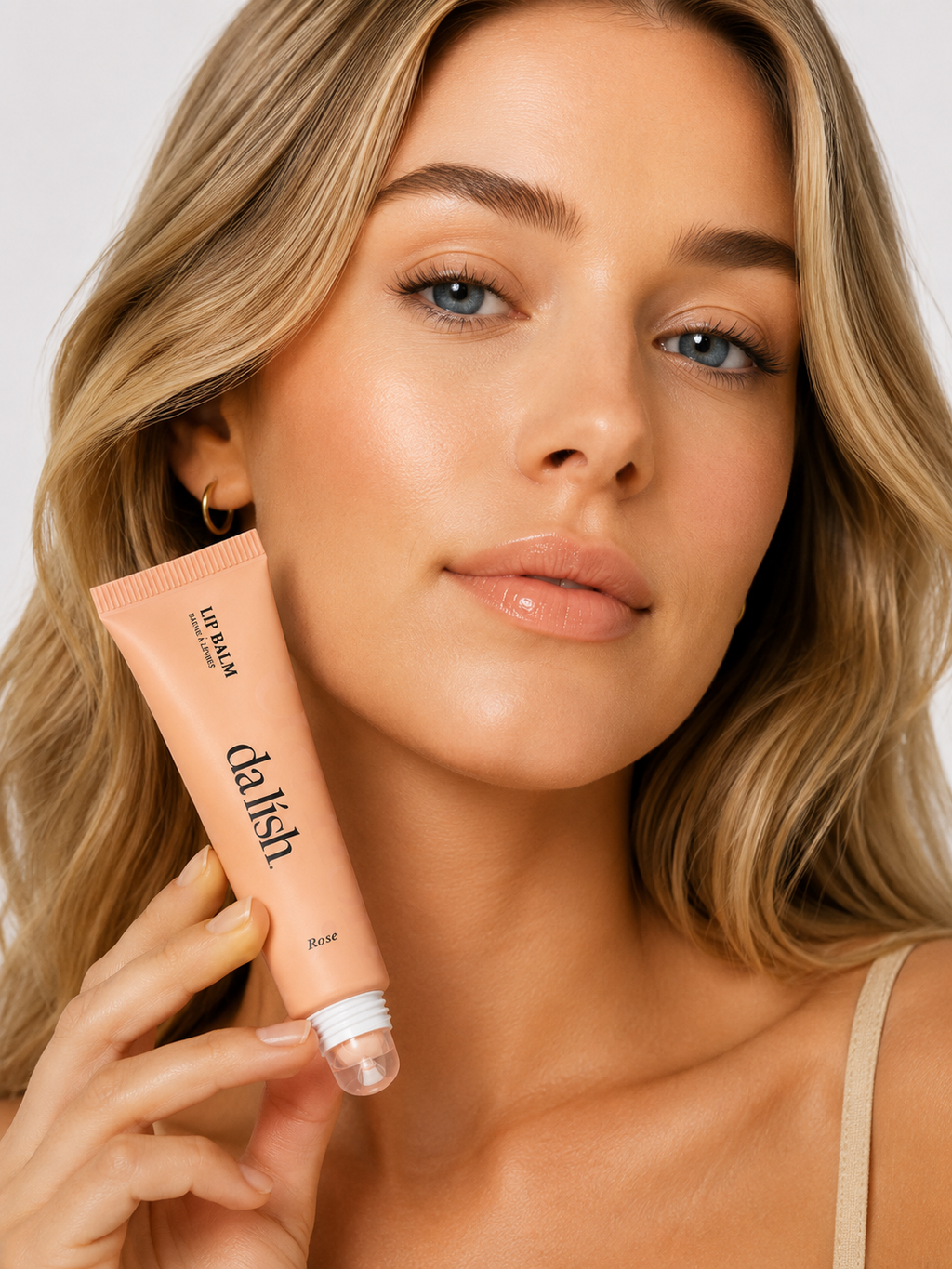 Hydrating tinted lip balm by da lish cosmetics in rose shade, softening lips with buildable, natural color.