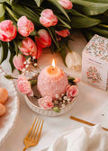 Decorative floral egg candle by Mimi & August featuring pastel colors and intricate floral designs on a smooth wax surface.