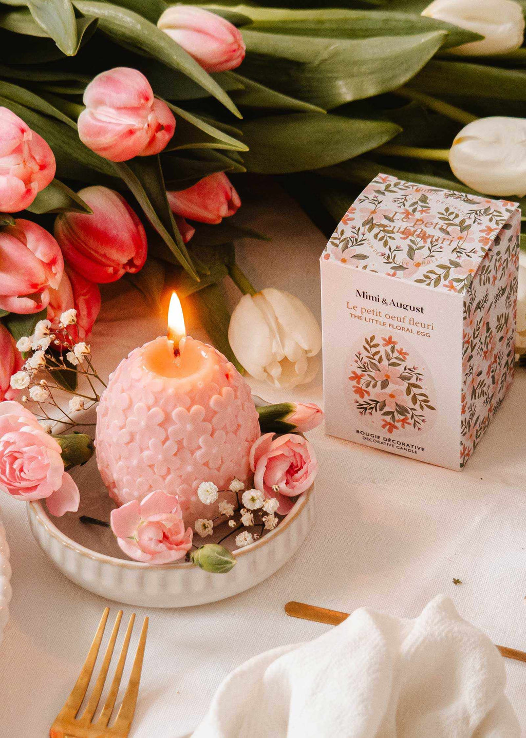 Decorative floral egg-shaped candle by Mimi & August featuring colorful flower patterns on a smooth surface.