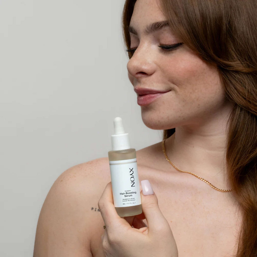 XYON Revitalize hair-boosting serum for women in a clear bottle with a dropper, designed for hair repair and strengthening.