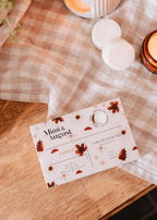 Amber soy wax melts in Mimi & August wax tarts packaging, showcasing warm amber-colored wax with a smooth surface.