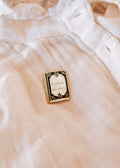 Mimi & August Booked All Day enamel pin featuring a colorful book design on a metal pin backing.