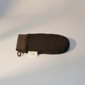 Dark brown exfoliating glove by Pure Wash with plush textured surface for gentle skin exfoliation during bath or shower.