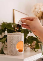 Mimi & August lilac-scented oil bottle with purple floral label, showcasing the scented oil product in a clear glass container.