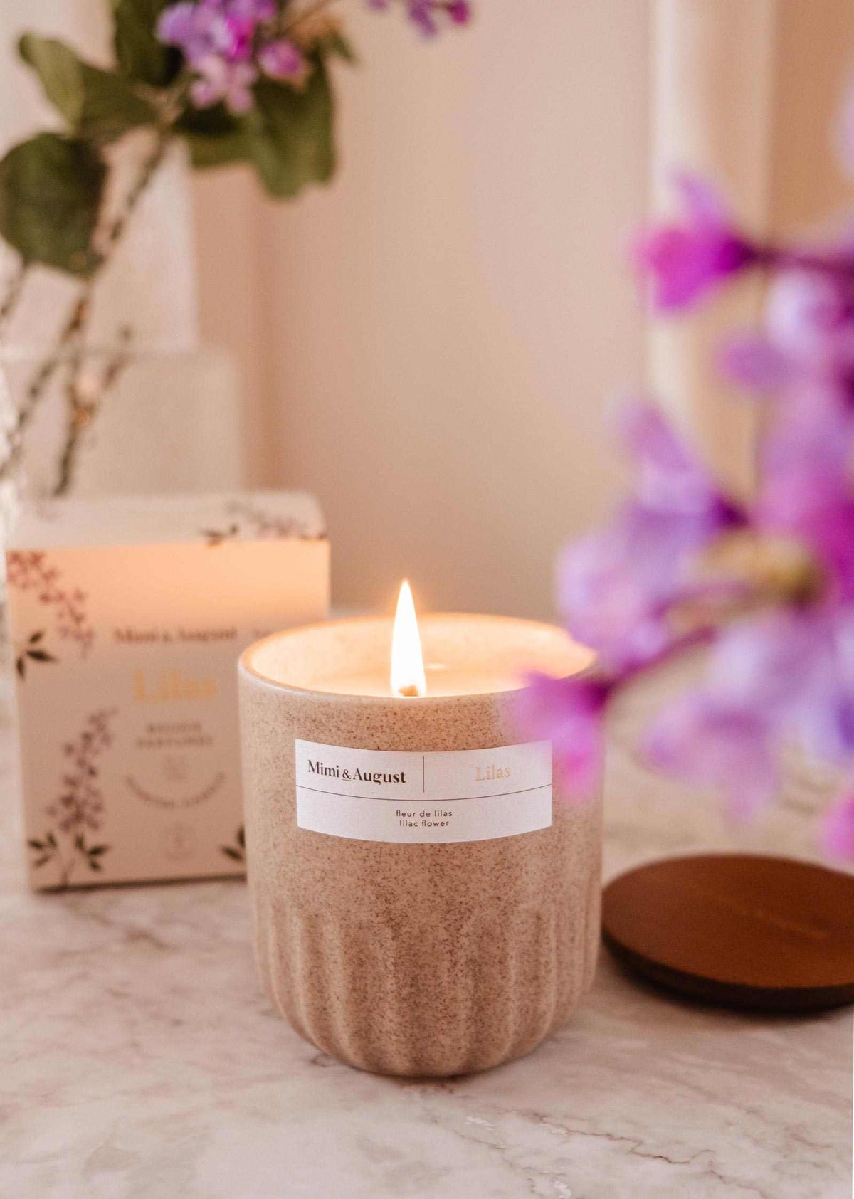 Lilac reusable soy candle by Mimi & August in a glass container, perfect for home decor and creating a cozy ambiance.