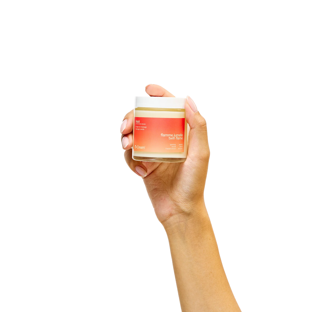 Peach and Cream massage candle melt, hand-held, with a soft glow, designed for soothing massage and relaxation.