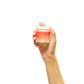 Peach and Cream massage candle melt, hand-held, with a soft glow, designed for soothing massage and relaxation.