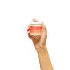 Peach and Cream massage candle melt, hand-held, with a soft glow, designed for soothing massage and relaxation.