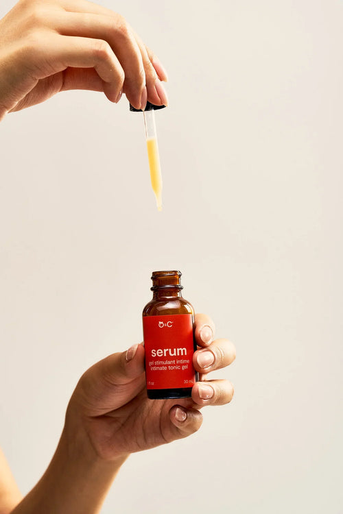 Peach and Cream arousal tonic serum in a sleek bottle, showcasing the product label and metallic gold display.