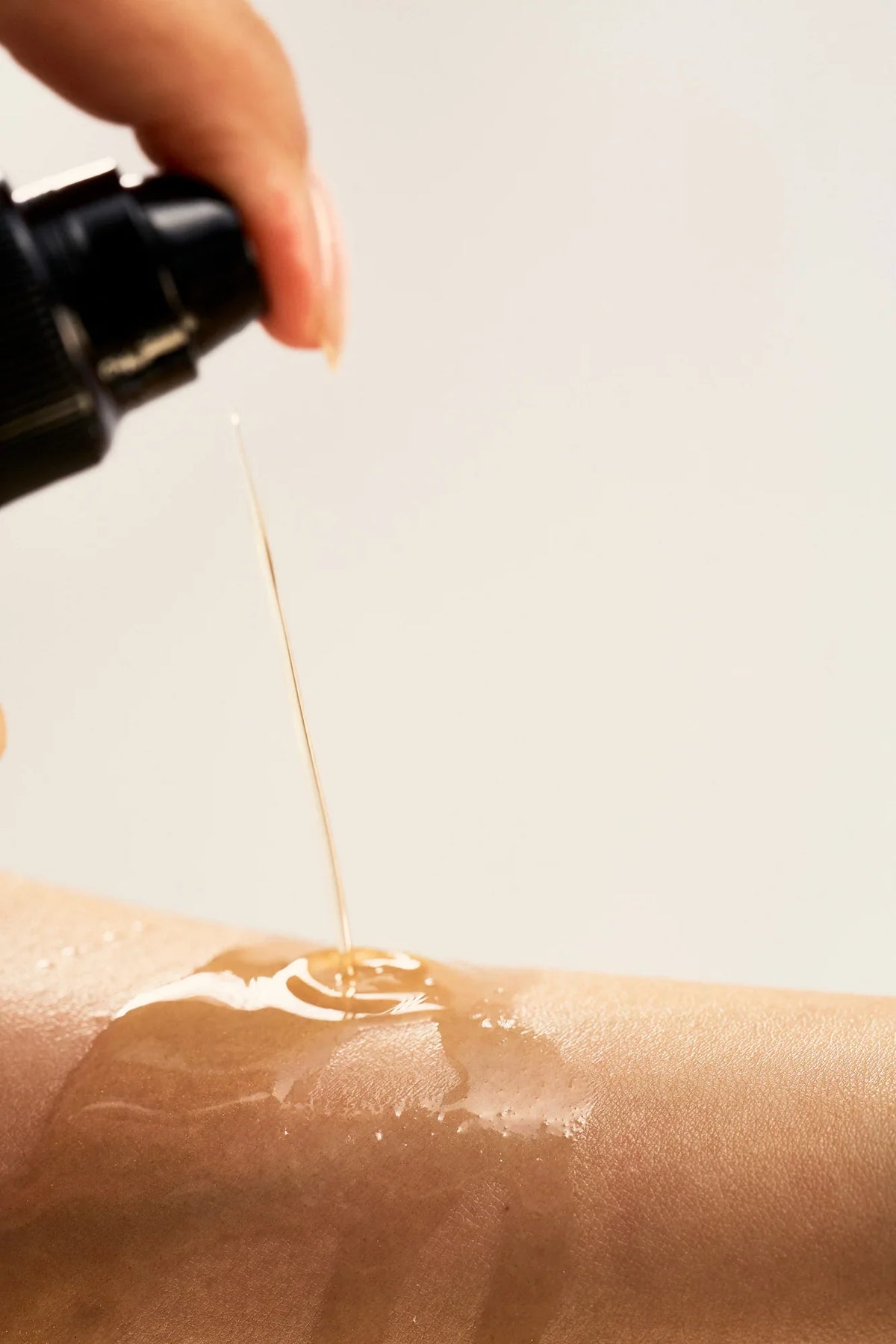 Peach and Cream® shimmer dry body oil with silk, showcasing a sleek bottle with a luxurious, shimmering liquid inside.