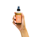 Peach and Cream® shimmer dry body oil with silk, featuring a sleek bottle and luxurious golden shimmer on a soft background.