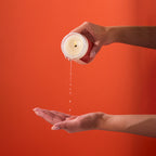 Peach and Cream massage candle melt in a glass jar, showing a soft, warm glow with a partially melted wax surface.