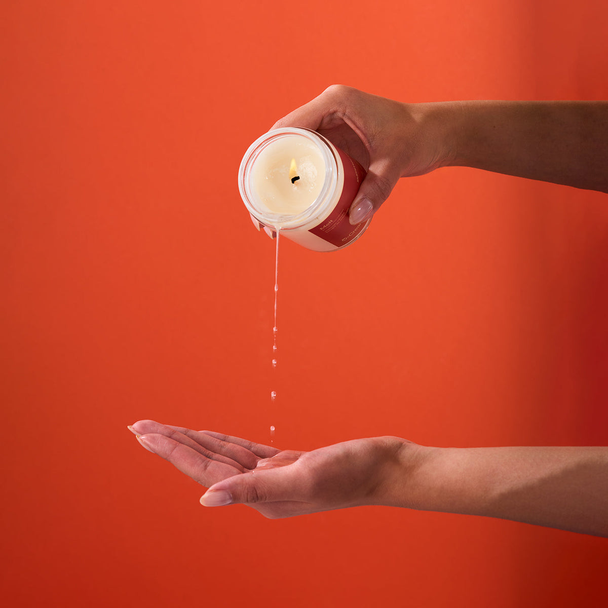 Peach and Cream massage candle melt in a glass jar, showing a soft, warm glow with a partially melted wax surface.
