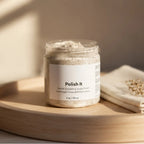 Pure Wash Polish It creamy exfoliant face scrub in a clear glass jar with beige cream texture visible.