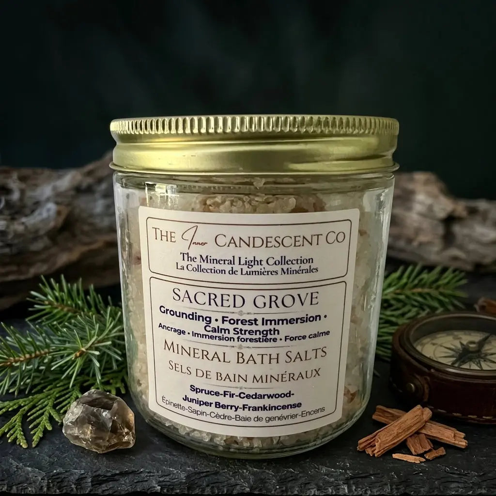 The InnerCandescent Co Sacred Grove grounding mineral bath salts with magnesium and minerals, shown in a glass jar with a wooden scoop.