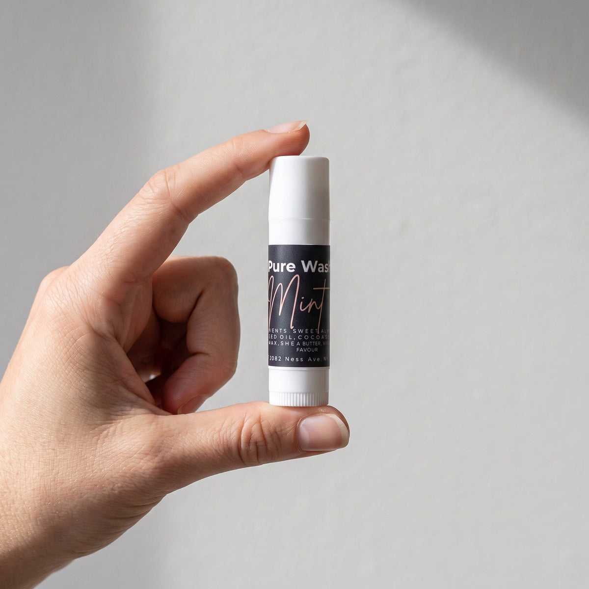 Pure Wash mint lip balm tube with a sleek design, showcasing the hydrating lip balm inside.