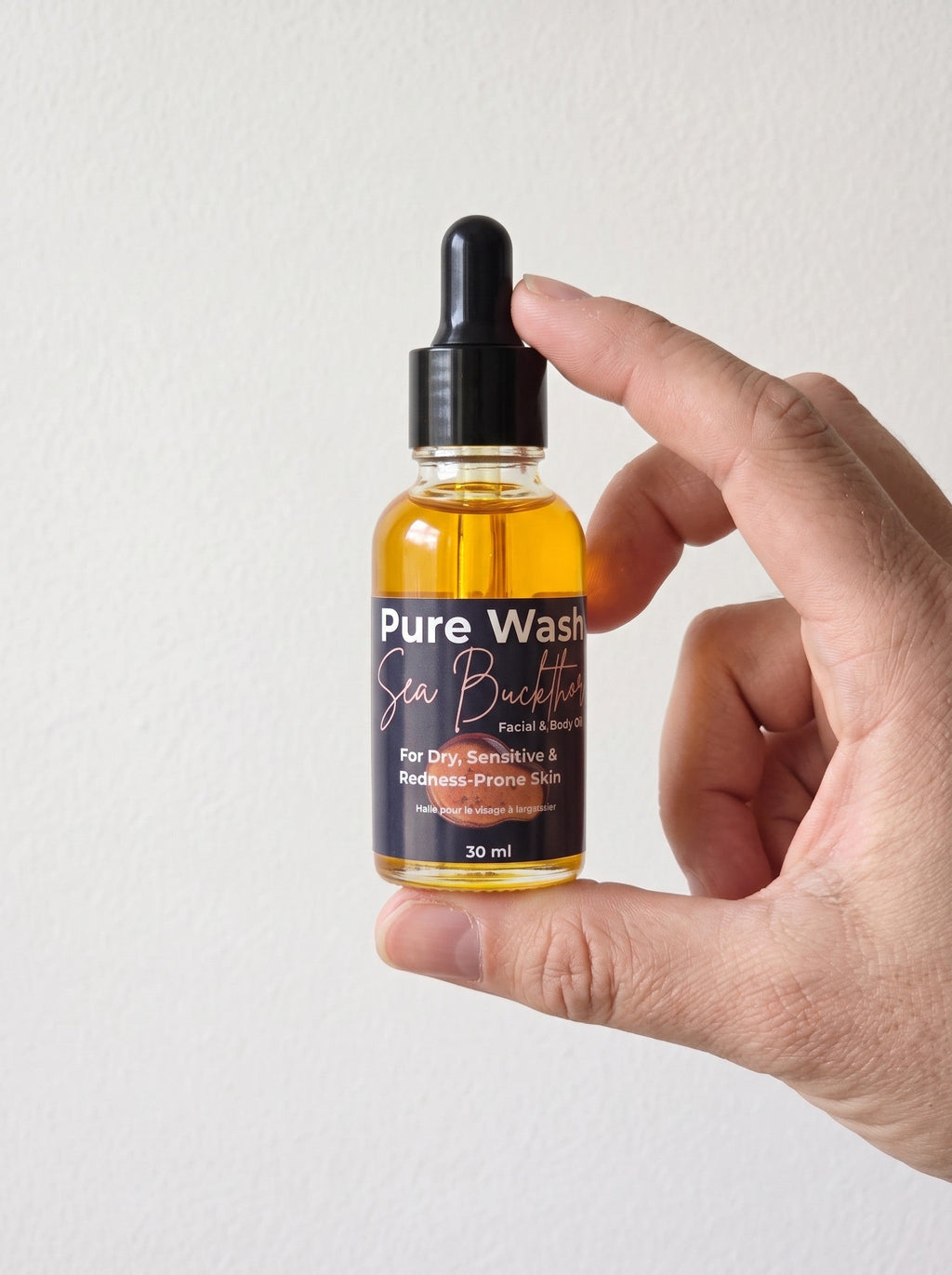 Pure Wash Sea Buckthorn Facial Oil bottle with dropper, showcasing the golden-colored oil in a sleek glass container.