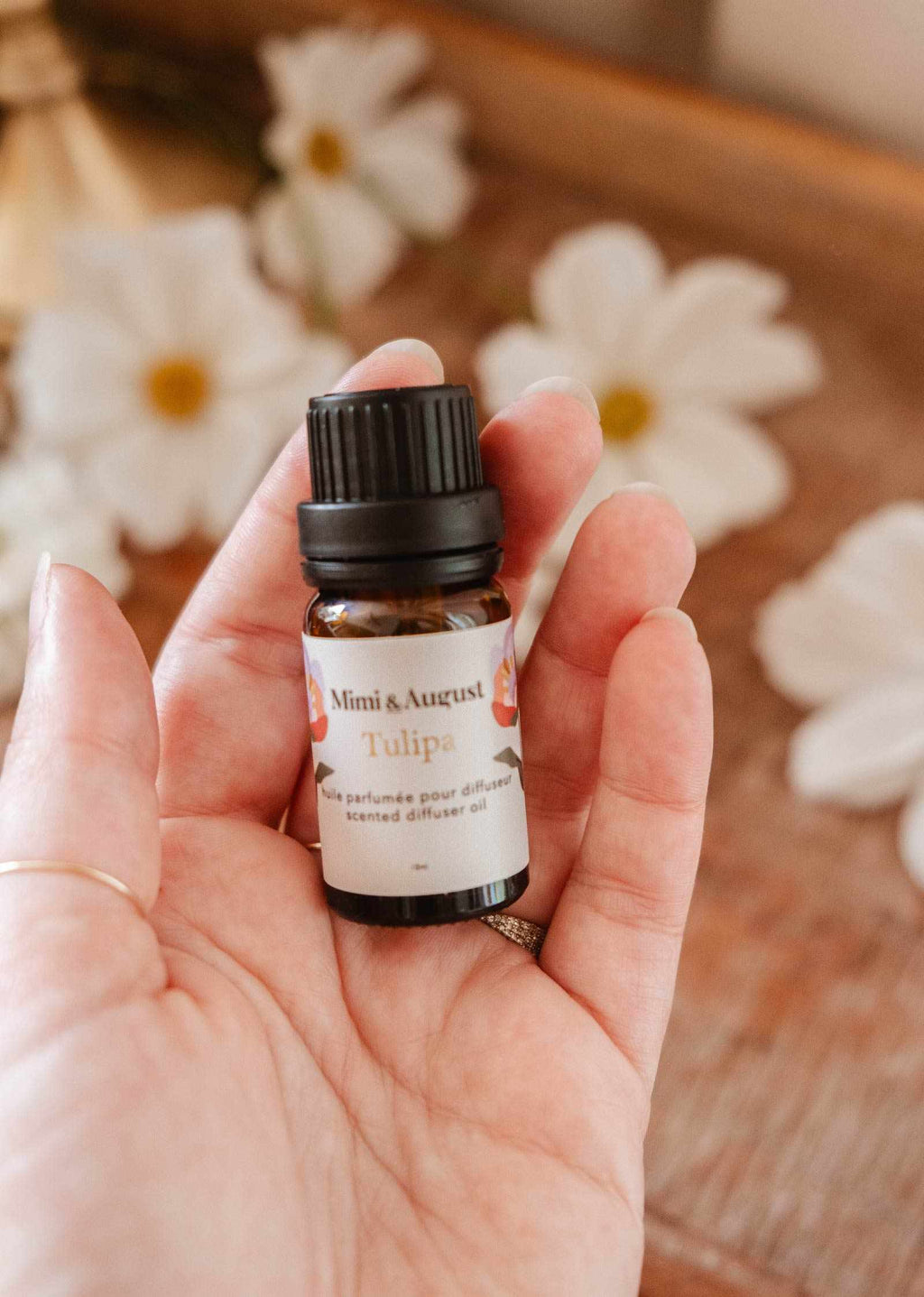 Glass bottle of Mimi & August Tulipa scented oil with a floral label, showcasing the elegant packaging and vibrant tulip design.